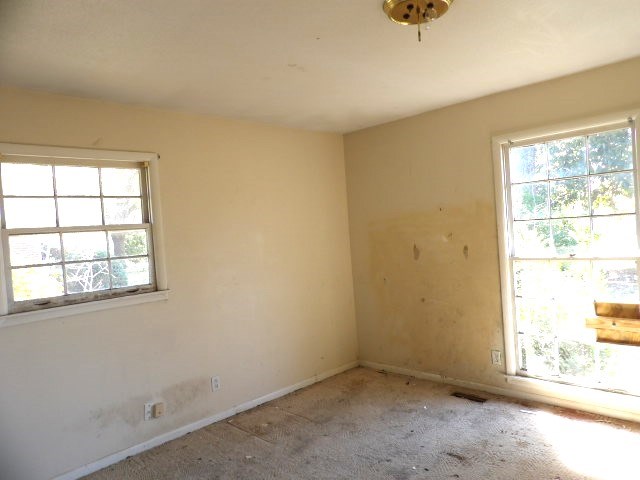 spare room with light carpet, baseboards, and visible vents