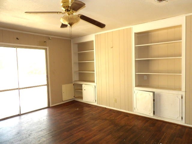 interior space featuring crown molding, dark wood finished floors, and ceiling fan