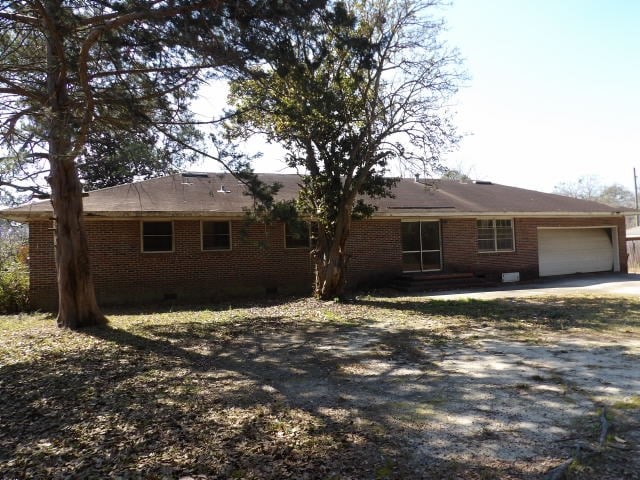 view of front of home with brick siding, driveway, and an attached garage