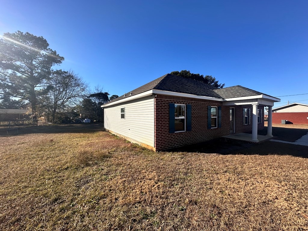 view of side of property with a lawn