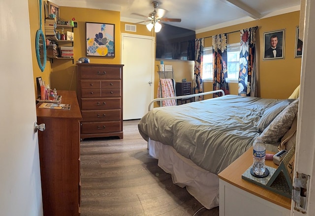bedroom with wood finished floors, visible vents, and ceiling fan