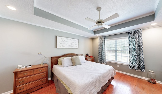 119 Willow Oaks Dr, Headland, AL 36345 - bedroom with baseboards, a raised ceiling, crown molding, and wood-type flooring