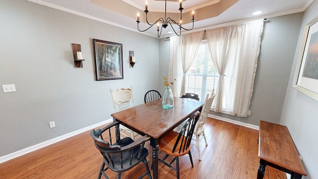 119 Willow Oaks Dr, Headland, AL 36345 - dining area featuring light wood-type flooring, a raised ceiling, baseboards, and crown molding