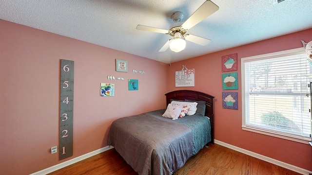 119 Willow Oaks Dr, Headland, AL 36345 - bedroom featuring a textured ceiling, wood finished floors, baseboards, and multiple windows