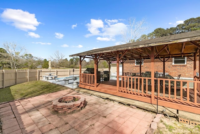 view of patio featuring a fenced in pool, an outdoor fire pit, a gazebo, a deck, and a fenced backyard