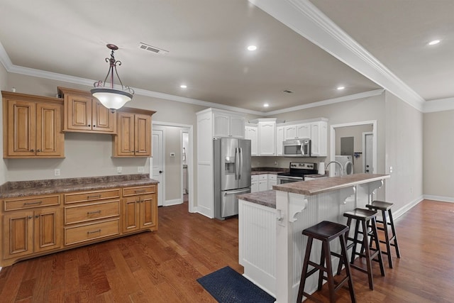 kitchen with dark wood-style flooring, washing machine and clothes dryer, stainless steel appliances, dark countertops, and a kitchen bar