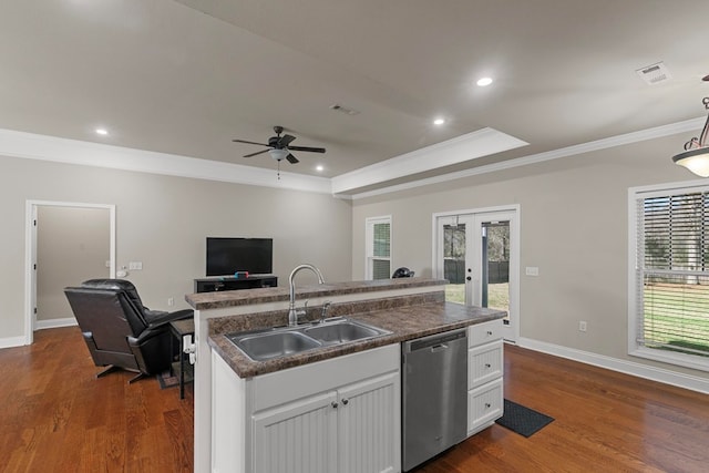 kitchen with a sink, white cabinets, open floor plan, dishwasher, and dark countertops