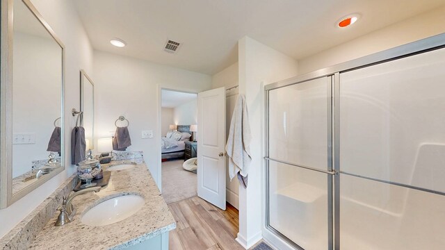469 Lantana Ct, Rehobeth, AL 36301 - bathroom with connected bathroom, a stall shower, double vanity, wood finished floors, and recessed lighting