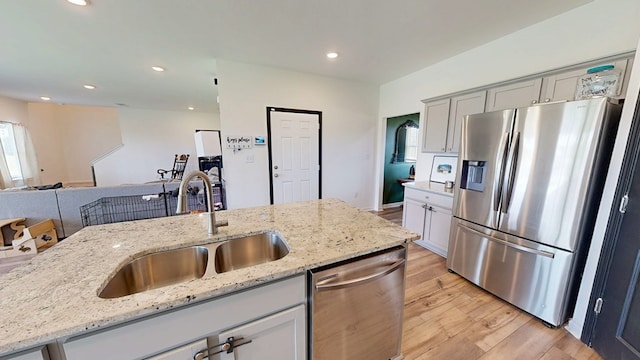 469 Lantana Ct, Rehobeth, AL 36301 - kitchen featuring appliances with stainless steel finishes, a sink, light wood finished floors, open floor plan, and light stone countertops