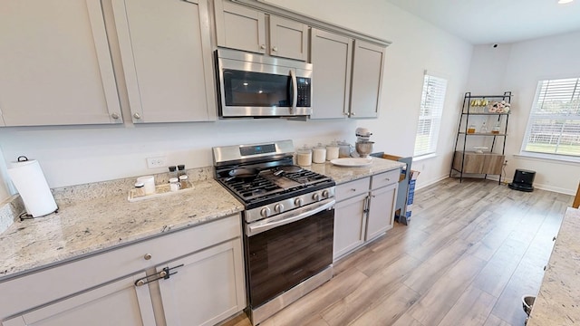 469 Lantana Ct, Rehobeth, AL 36301 - kitchen featuring stainless steel appliances, light wood-style flooring, gray cabinets, light stone counters, and baseboards