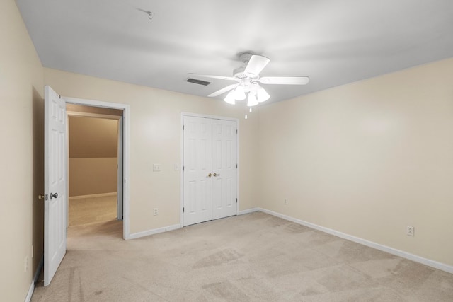 unfurnished bedroom featuring ceiling fan, light colored carpet, and a closet