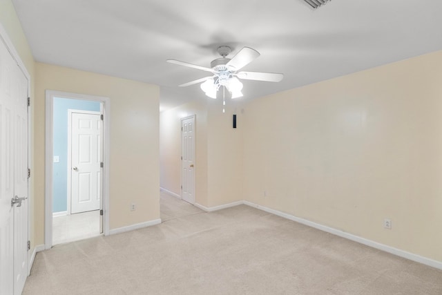 empty room featuring ceiling fan and light colored carpet