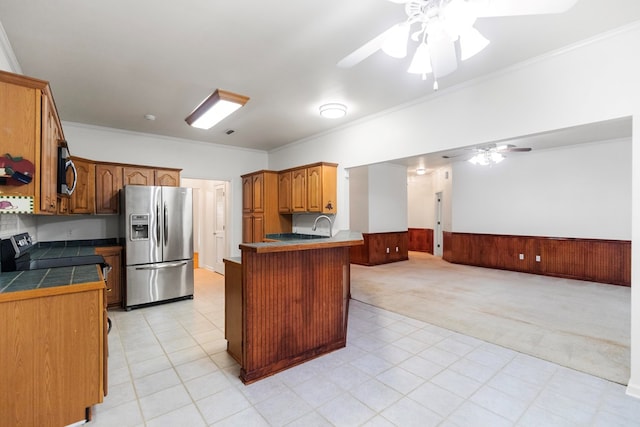 kitchen with ceiling fan, kitchen peninsula, crown molding, and appliances with stainless steel finishes