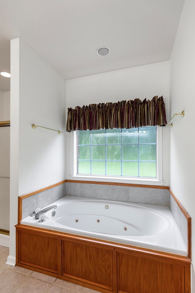 bathroom featuring tile patterned flooring, a tub to relax in, and a healthy amount of sunlight