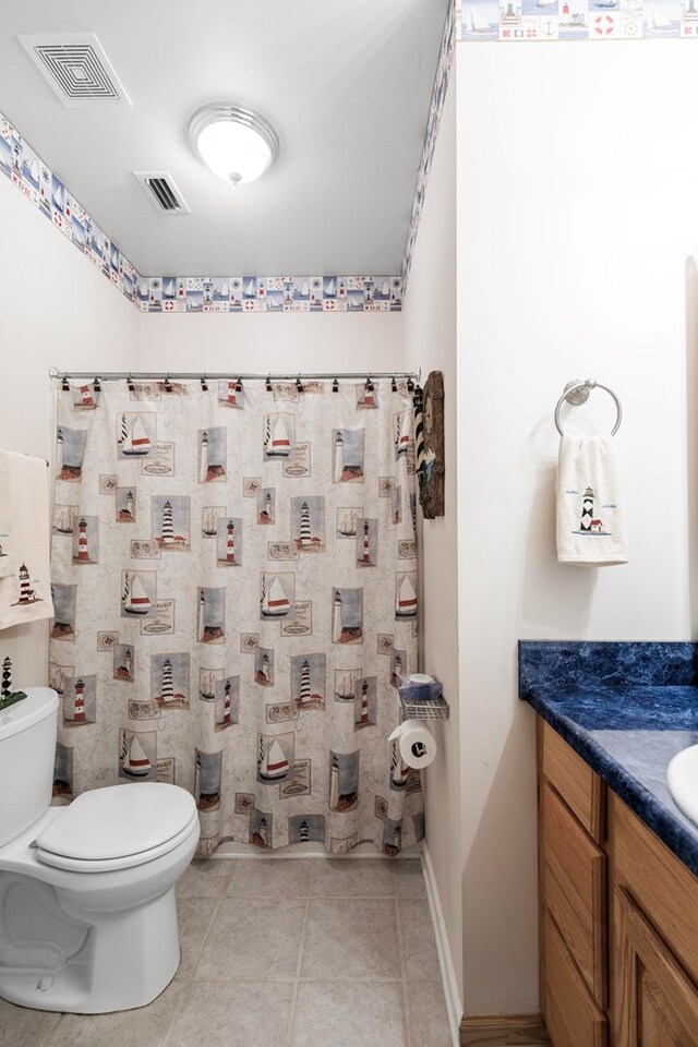 bathroom featuring tile patterned flooring, vanity, and toilet