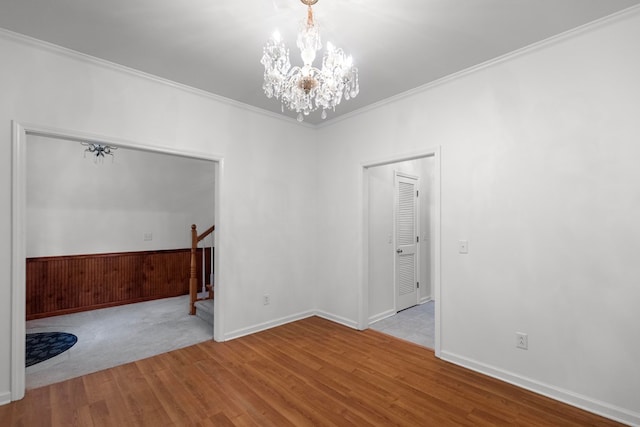 unfurnished room featuring light wood-type flooring, an inviting chandelier, and crown molding