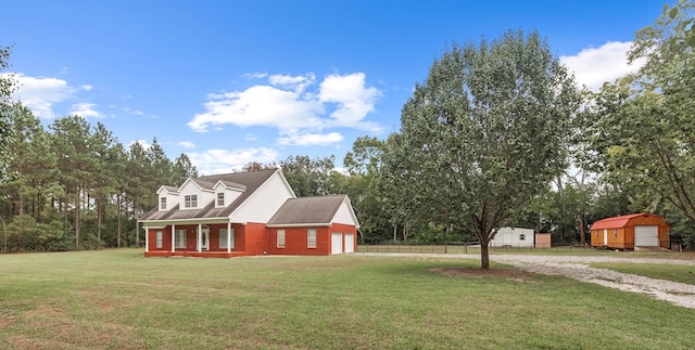 view of side of home featuring a lawn, covered porch, and a garage