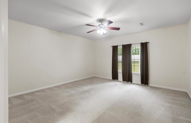 empty room featuring ceiling fan and light colored carpet