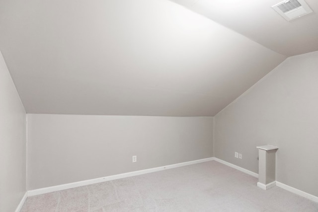 bonus room with light colored carpet and lofted ceiling