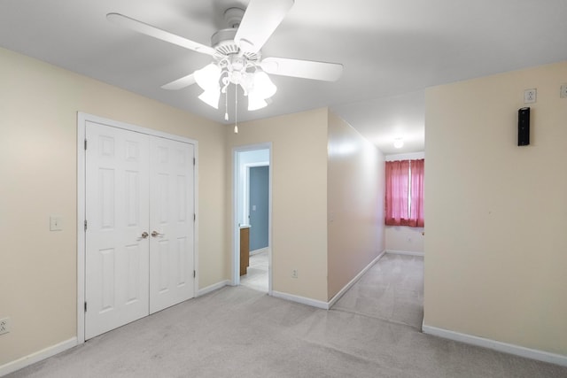 unfurnished bedroom with a closet, ceiling fan, and light colored carpet