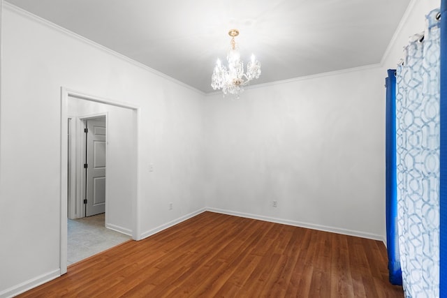 spare room with crown molding, light hardwood / wood-style floors, and an inviting chandelier