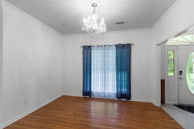 foyer featuring a chandelier, hardwood / wood-style flooring, and crown molding