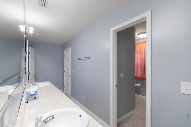 bathroom with tile patterned floors, vanity, and an inviting chandelier