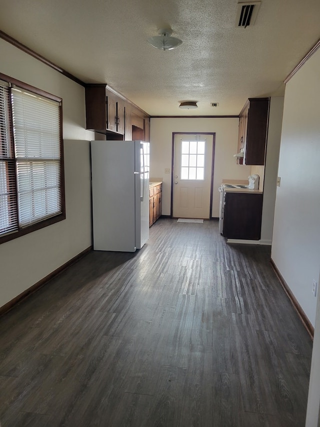 kitchen featuring dark hardwood / wood-style flooring, range with electric cooktop, a textured ceiling, crown molding, and white fridge