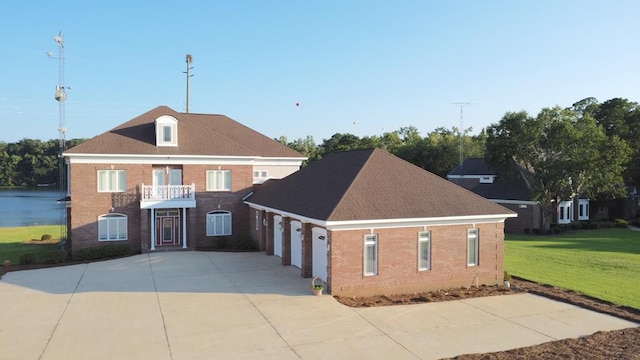 view of front facade featuring a balcony and a front yard