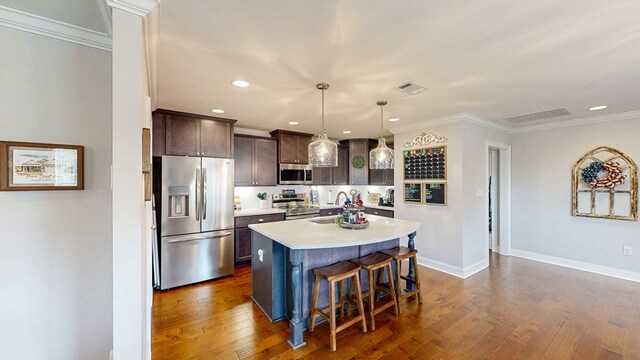 160 Sandbed Rd, Newton, AL 36352 - kitchen featuring appliances with stainless steel finishes, light countertops, dark brown cabinets, dark wood finished floors, and a breakfast bar