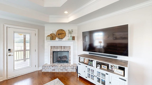 160 Sandbed Rd, Newton, AL 36352 - living room featuring dark wood-style flooring, a raised ceiling, a brick fireplace, ornamental molding, and recessed lighting