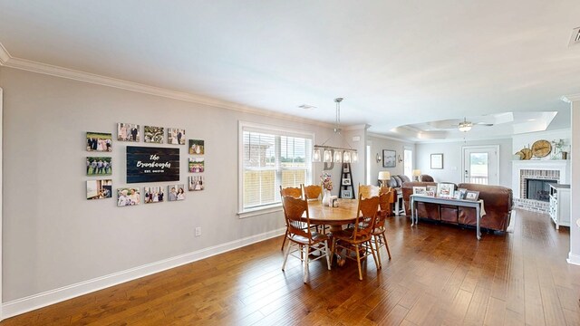 160 Sandbed Rd, Newton, AL 36352 - dining area with ornamental molding, a ceiling fan, dark wood-type flooring, a fireplace, and a tray ceiling