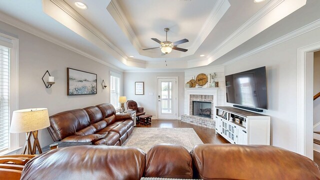 160 Sandbed Rd, Newton, AL 36352 - living room with a raised ceiling, ceiling fan, dark wood-type flooring, crown molding, and a brick fireplace