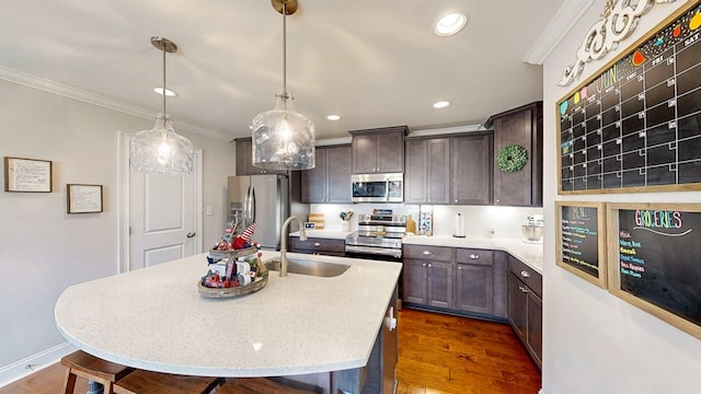 160 Sandbed Rd, Newton, AL 36352 - kitchen with stainless steel appliances, ornamental molding, dark brown cabinets, dark wood-style floors, and a kitchen island with sink
