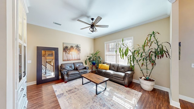 living room featuring dark wood-type flooring, ceiling fan, and crown molding