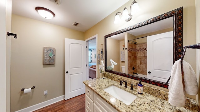 bathroom featuring vanity, hardwood / wood-style flooring, and toilet