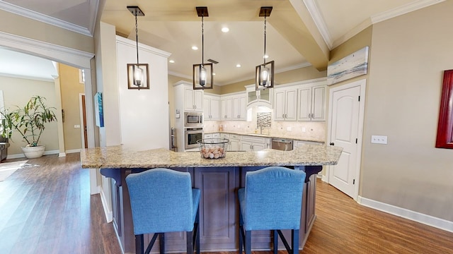 kitchen with tasteful backsplash, white cabinetry, a kitchen breakfast bar, hanging light fixtures, and stainless steel appliances