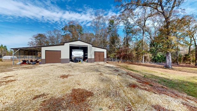 view of outdoor structure featuring a carport, a garage, and a yard