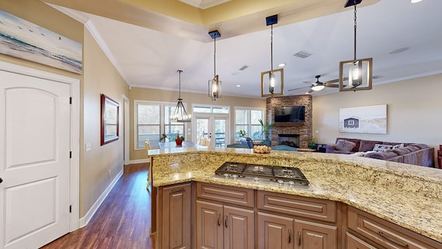 kitchen with ornamental molding, stainless steel gas cooktop, and pendant lighting