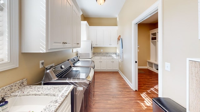 kitchen featuring sink, independent washer and dryer, light stone countertops, light hardwood / wood-style floors, and white cabinets