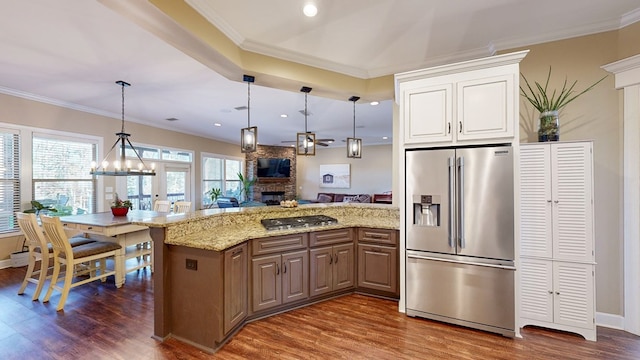 kitchen featuring crown molding, a stone fireplace, and stainless steel appliances