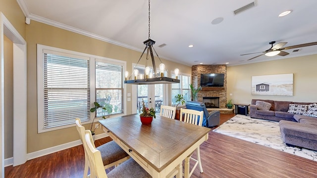 dining room with crown molding, dark hardwood / wood-style floors, and a fireplace