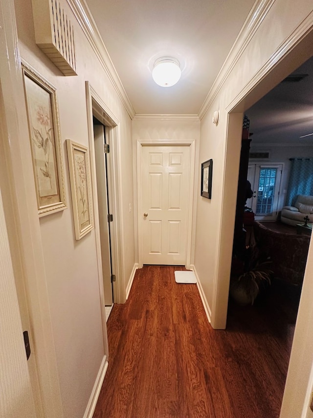 hallway featuring dark wood-style floors, baseboards, and ornamental molding