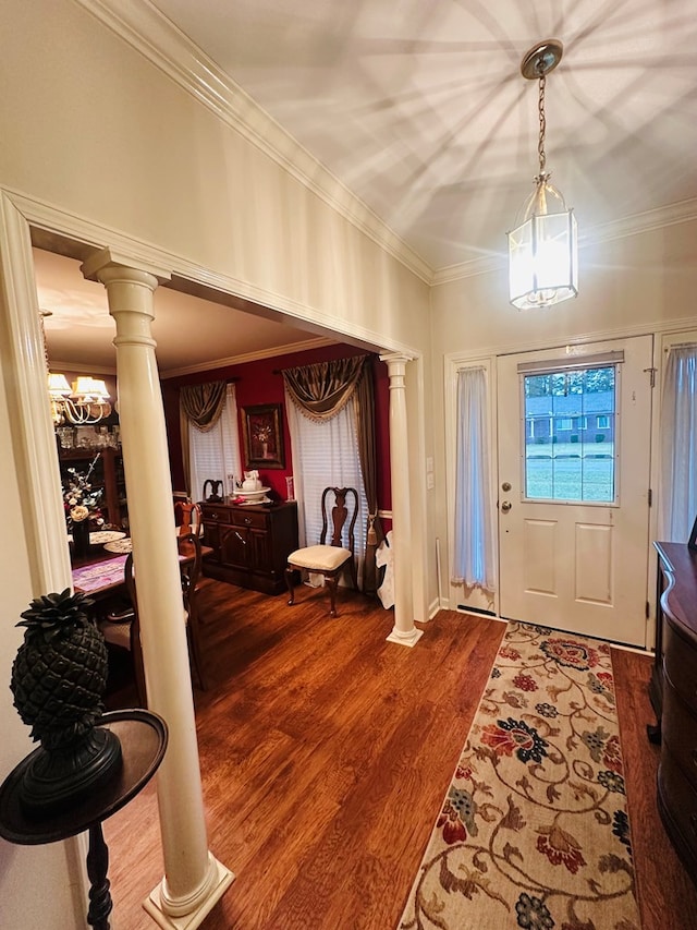 foyer featuring decorative columns, wood finished floors, and ornamental molding