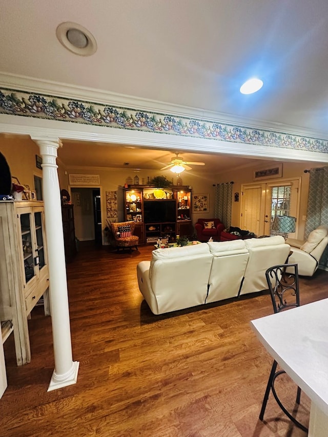 living area with a ceiling fan, wood finished floors, crown molding, and ornate columns