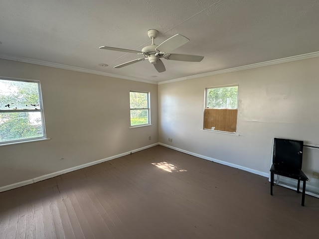 spare room featuring hardwood / wood-style floors, ceiling fan, baseboards, and ornamental molding