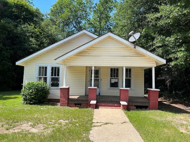 bungalow with covered porch and a front lawn