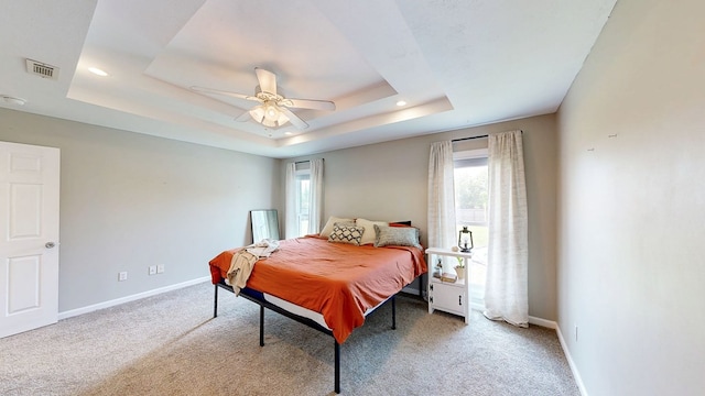 carpeted bedroom featuring visible vents, baseboards, recessed lighting, a raised ceiling, and a ceiling fan