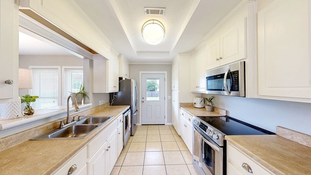 kitchen with visible vents, a sink, white cabinets, and stainless steel appliances