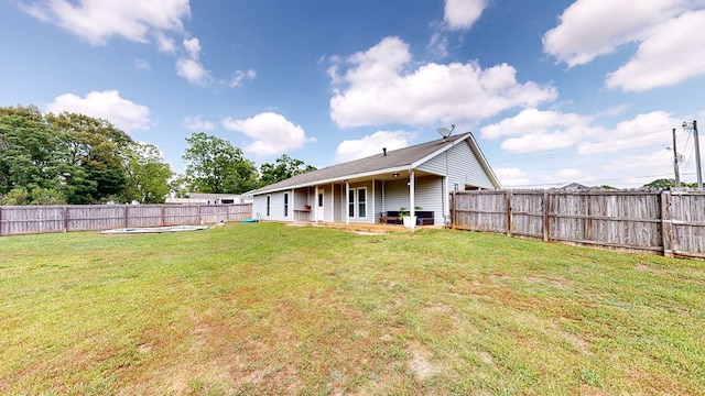 back of property featuring a fenced backyard and a lawn